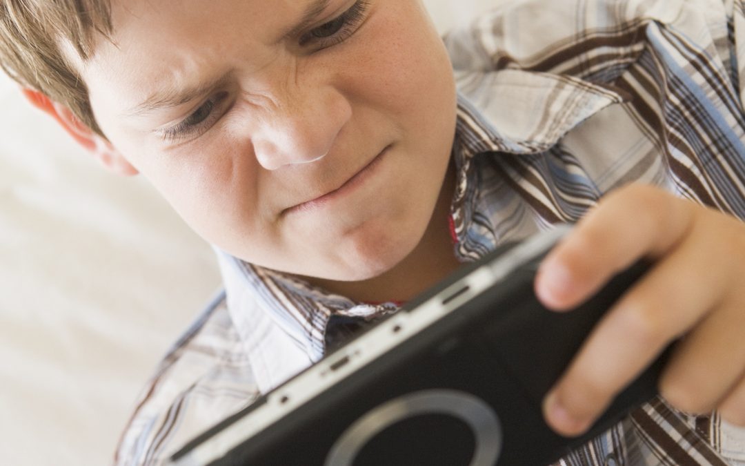 young-boy-with-handheld-game-indoors-looking-unhappy_St5EOoRrj-1080x675